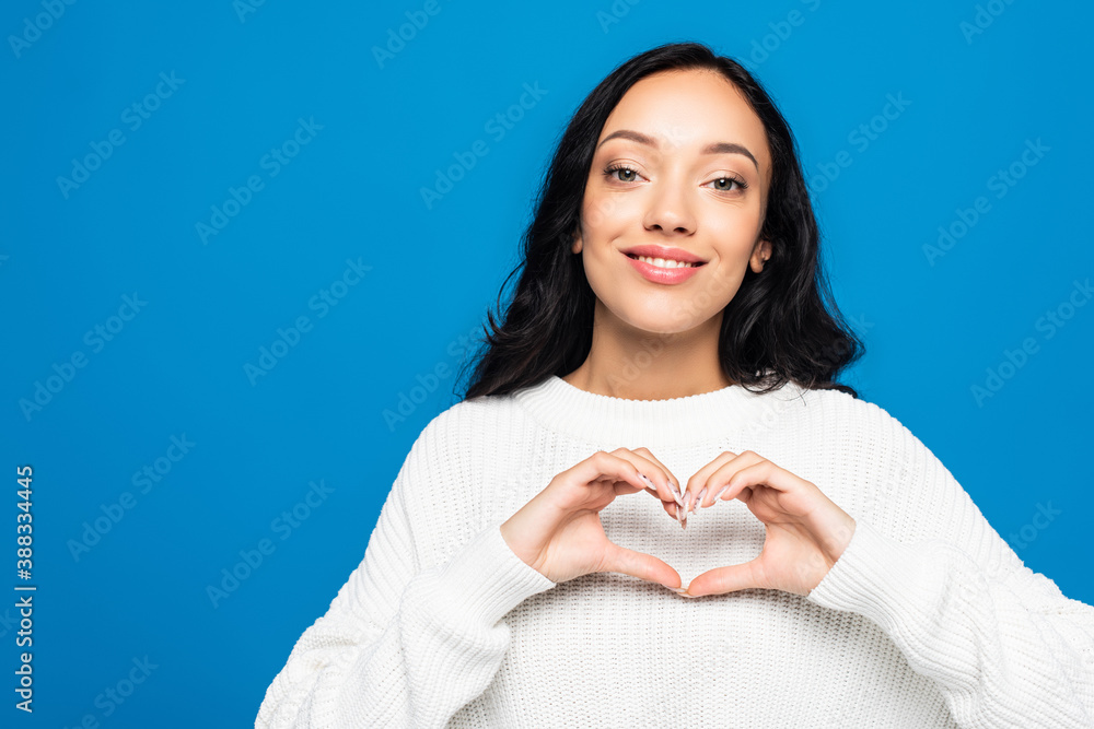 brunette woman showing heart sign with hands isolated on blue brunette woman showing heart sign with hands isolated on blue