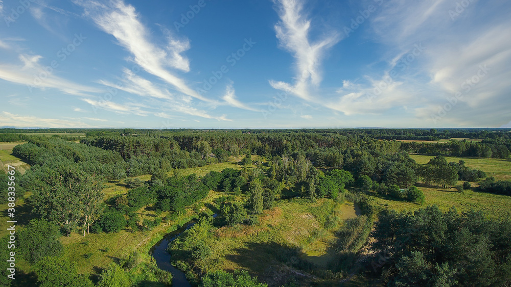 Low flyover over a small wild river on a summer day, river Grabia, Poland.