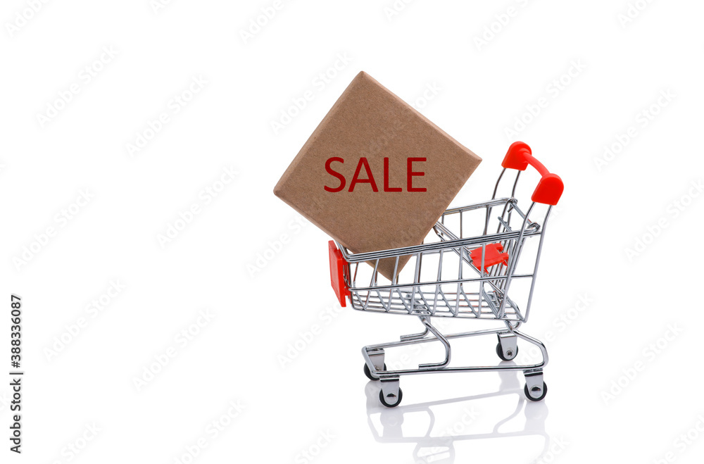 Paper box in a shopping cart with red sale sign, isolated on white background.