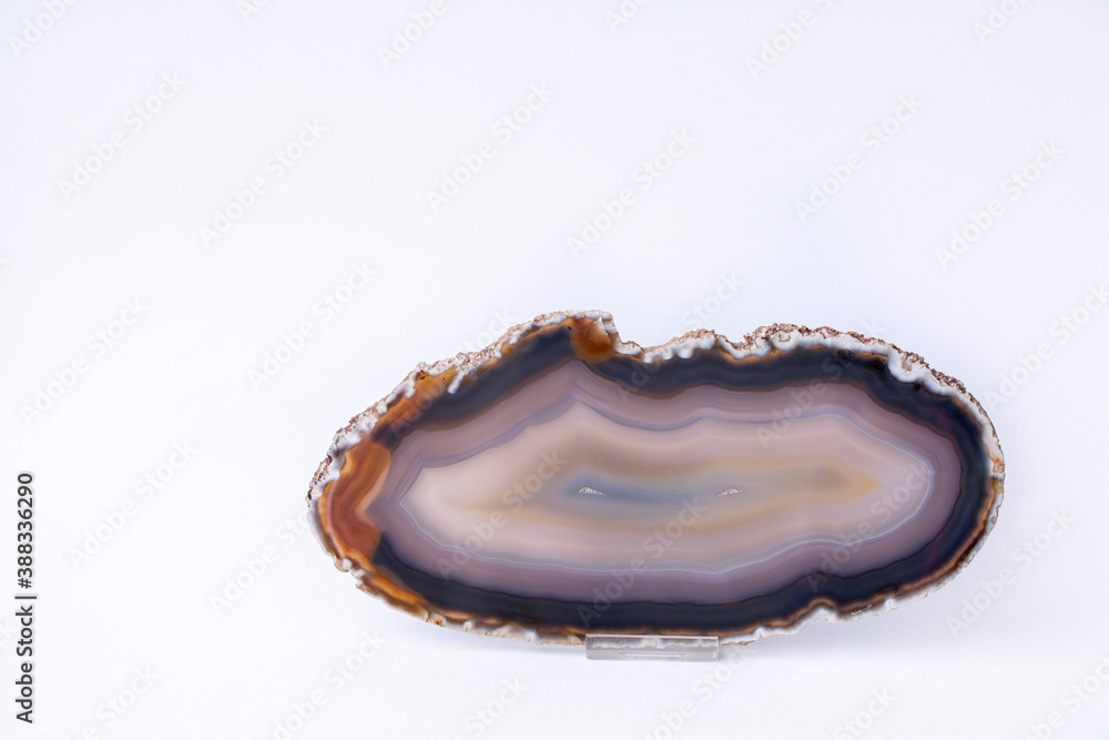 Beautiful slice of striped agate on a white background, with copy space. Beautiful slice of striped agate on a white background, with copy space.