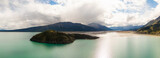 Gorgeous View of Scenic Island surrounded by Turquoise Lake and Mountains in Canadian Nature. Aerial Drone Shot. Yukon, Canada.