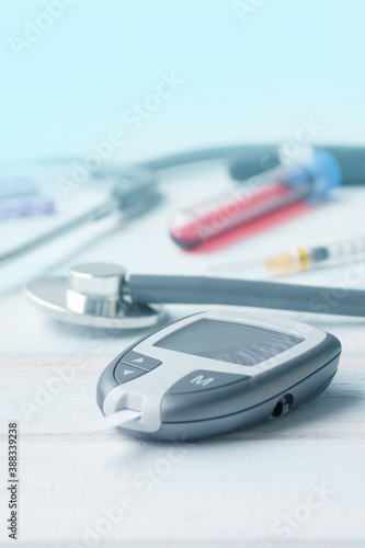 Digital glucometer and lancet pen, stethoscope, blood in vitro, on white background, concept of health, medical technology, patient monitoring