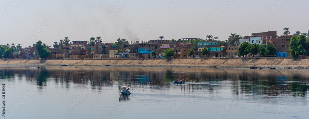 Panoramic of a traditional Egyptian villages on the bank of the Nile river. Views sailing on the cruise on the Nile river from Luxor to Aswer, Egypt