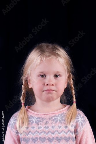 Closeup portrait of little girl isolated on black background