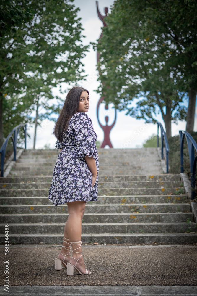 Mixed Race, Plus Sized Model Standing On Steps In Park Mixed Race, Plus Sized Model Standing On Steps In Park