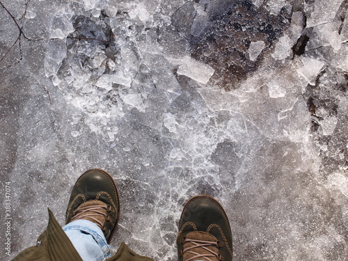 A person's winter boots on an icy road.