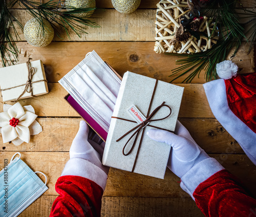 Covid-19 Christmas shot of Santa Claus hands in white gloves holding 