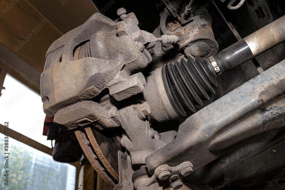 Drive shaft covered with rubber, visible disc and brake caliper, seen