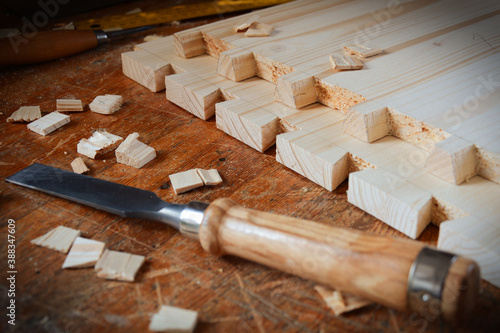 Dovetail joint on working table. Chisel and wood chips. Detail of wood joinery in spruce wood. Picture taken in woodworking workshop. 