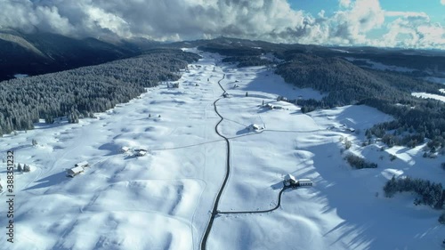 Winter beautiful drone mountain view of a big and snowy valley with road photo