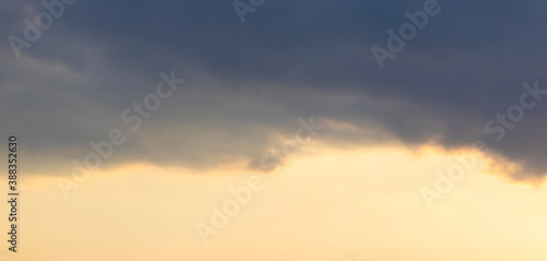 Dark cloud in the bright sky at sunset