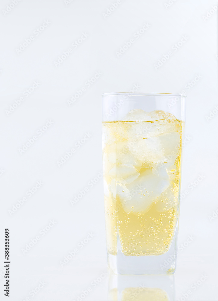 Alcohol with ice in glass on white table in vertical frame Alcohol with ice in glass on white table in vertical frame