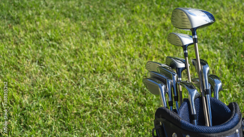 Golf sticks on green grass golf course, close up view.