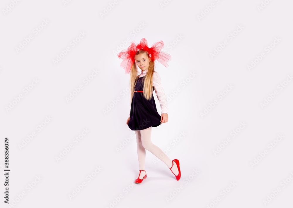 schoolgirl with bright tulle bows on her head in school clothes on a white background schoolgirl with bright tulle bows on her head in school clothes on a white background