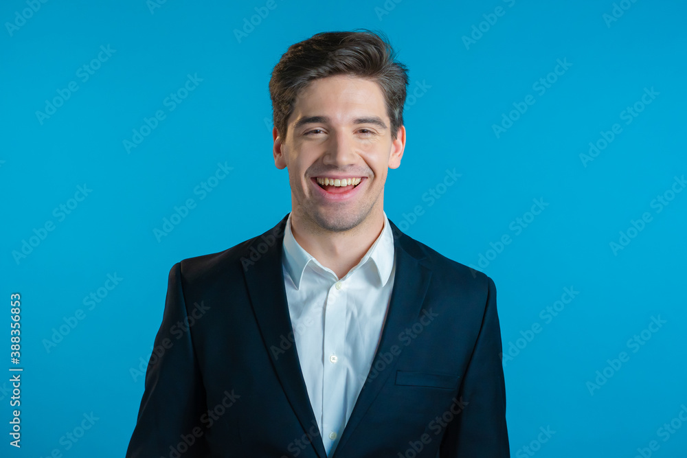 Portrait of young successful confident businessman isolated on blue studio background. Man in business suit looking to camera and smiling. Portraiture of handsome guy. Portrait of young successful confident businessman isolated on blue studio background. Man in business suit looking to camera and smiling. Portraiture of handsome guy.