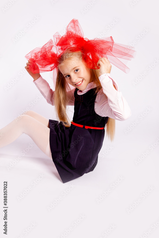 schoolgirl with bright tulle bows on her head in school clothes on a white background schoolgirl with bright tulle bows on her head in school clothes on a white background