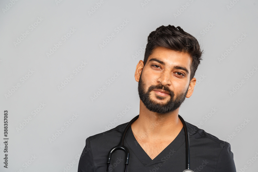 Fototapeta premium young indian male doctor or surgeon with stethoscope on gray background