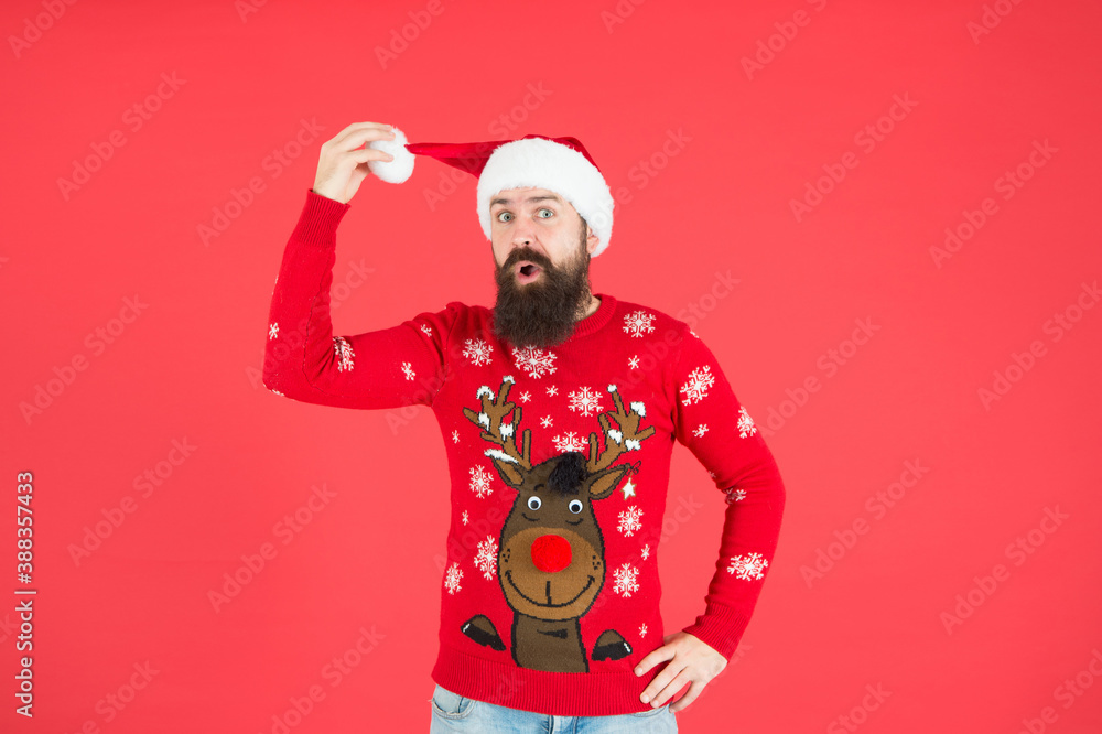 surprised bearded guy in warm knitted sweater and santa claus hat celebrate winter holiday of chistmas and feel merry about xmas gifts, knitwear fashion