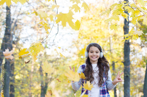 autumn kid fashion. inspiration. happy childhood. back to school. girl with leaves in park. fall beauty in forest. enjoy music in earphones. education online and e-learning. Ready for new adventures