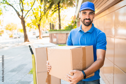 Wallpaper Mural Delivery man carrying package outdoors. Torontodigital.ca