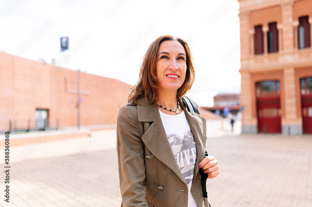 Fototapeta premium Beautiful middle aged woman walking through the city.
