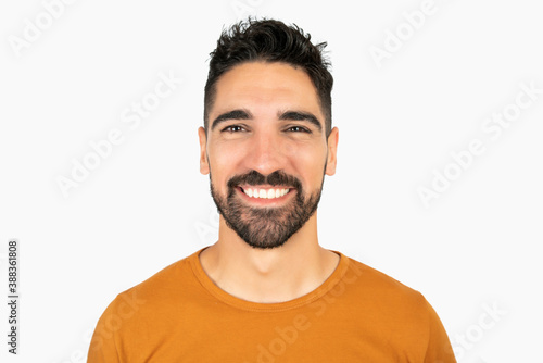 Young man smiling against white background.