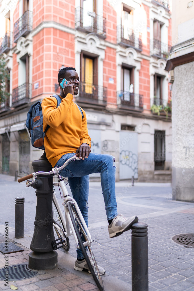 Black Man Having Phone Call Sitting on his Bike Outdoors.