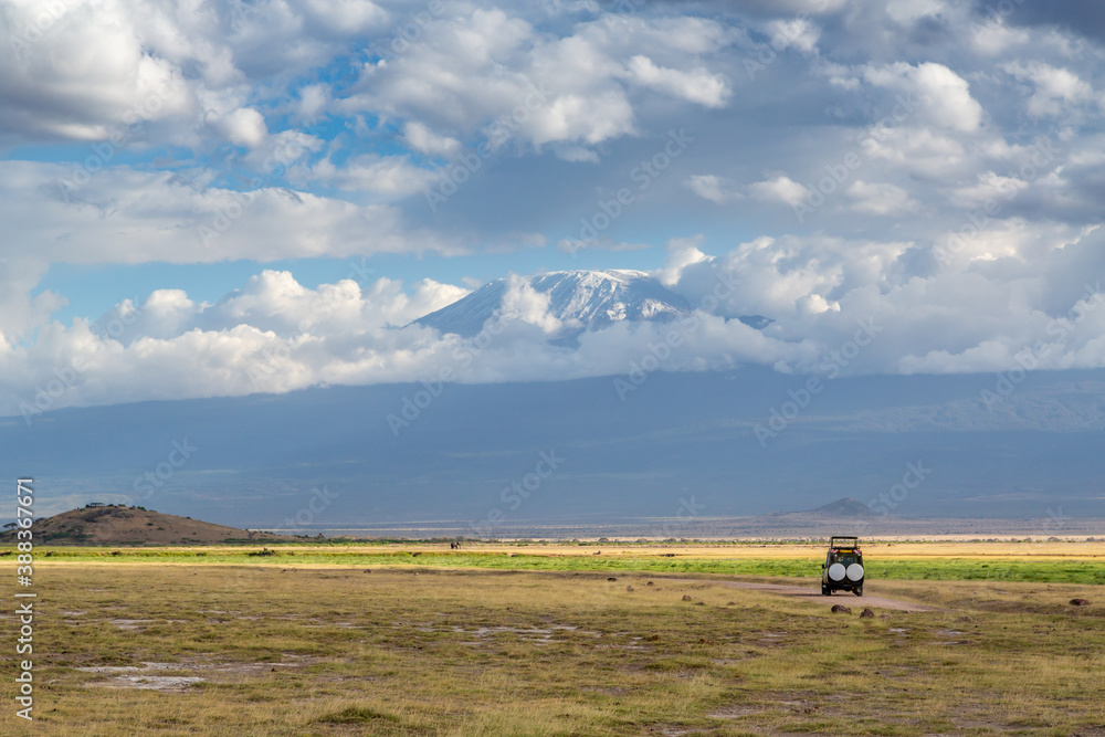 Safari Vehicle on a Road Near Mount Kilimanjaro in Amboseli National Park, Kenya, Africa Safari Vehicle on a Road Near Mount Kilimanjaro in Amboseli National Park, Kenya, Africa