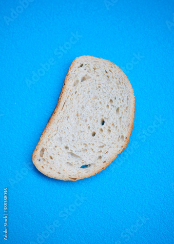 Slice of white wheat bread on a blue background.