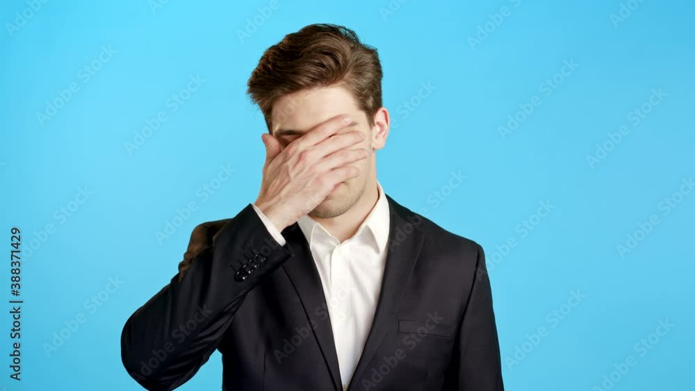 Portrait of business man doing facepalm gesture, like no, I forgot. Unhappy guy in suit feeling sorrow, regret, drama, failure. He isolated on blue wall Portrait of business man doing facepalm gesture, like no, I forgot. Unhappy guy in suit feeling sorrow, regret, drama, failure. He isolated on blue wall