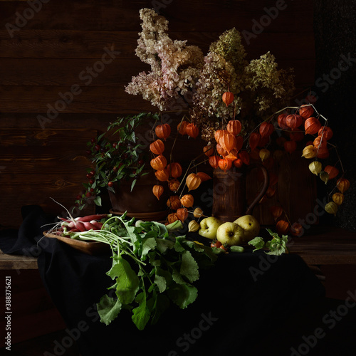 Vegetables and fruits next to a jug of physalis.