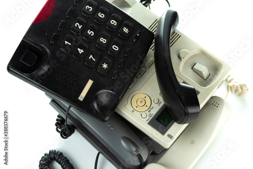 A bunch of old landline telephones with push-button dialers. On a white background. photo