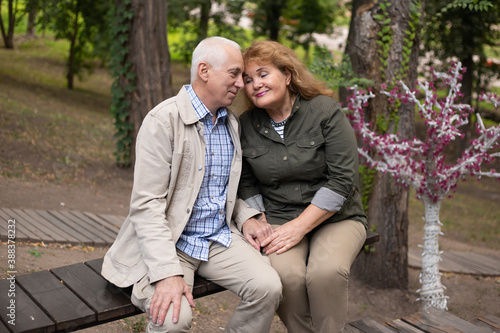 Senior elder couple together in park in spring or autumn. Beautiful love relation and care of retirement old people. © Marharyta