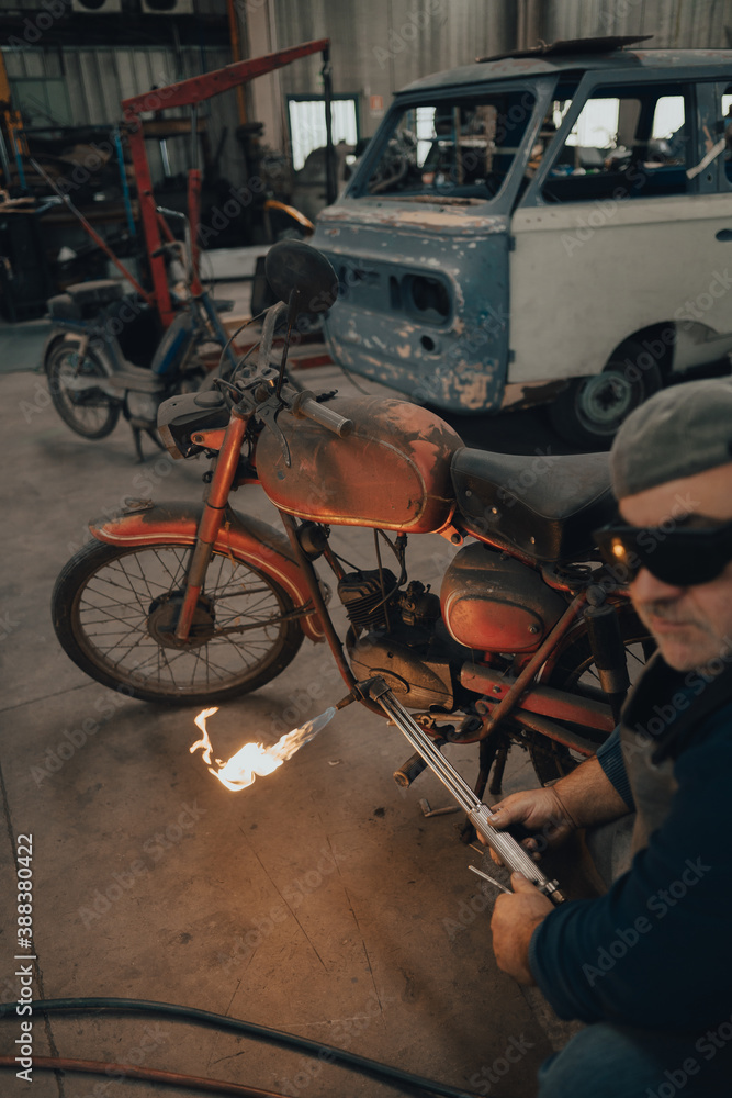 Mechanic works a vintage motorcycle in the workshop
