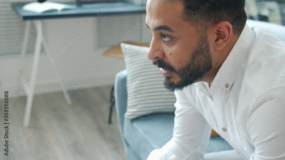 Close-up of emotional mixed race man playing video game pressing joystick buttons speaking concentrated on gaming at home. Leisure and youth concept. Close-up of emotional mixed race man playing video game pressing joystick buttons speaking concentrated on gaming at home. Leisure and youth concept.