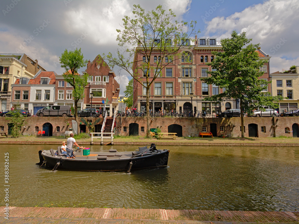 Naklejka premium `old canal` in Utrecht, with typical dutch houses, with cellars coming out on an old wharf