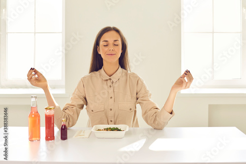 Foto Happy relaxed woman meditating before meal during lunch break at home or in offi