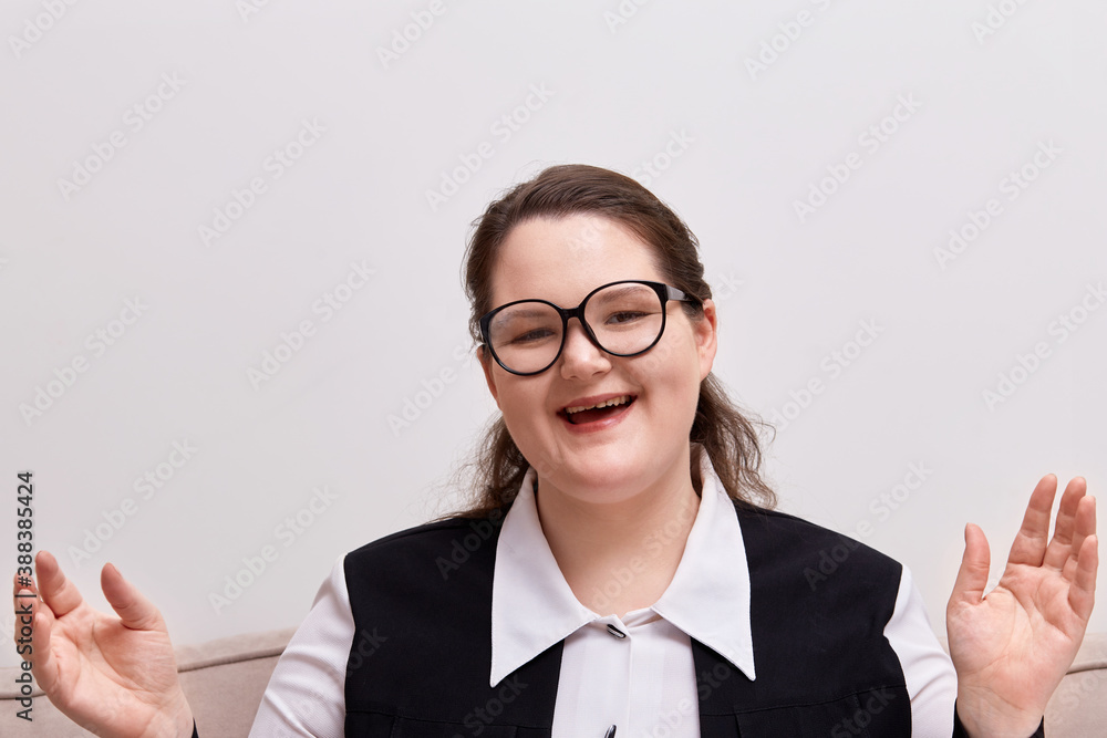 Business woman looks at the camera, laughing , hands apart. Black - rimmed eyeglasses. Business woman looks at the camera, laughing , hands apart. Black - rimmed eyeglasses.