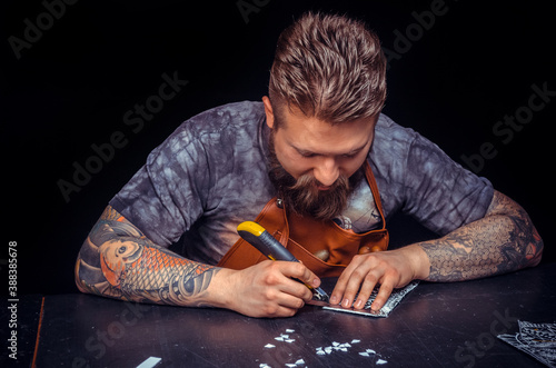 Leather cutter creating leatherwork in his place of work photo