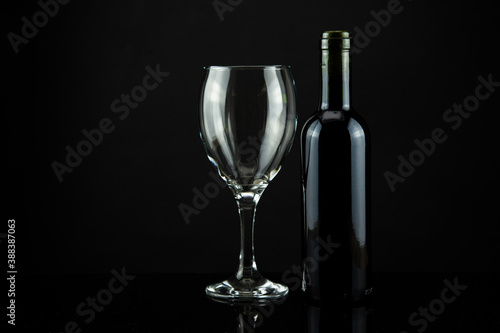 wine bottle and glass, black background
