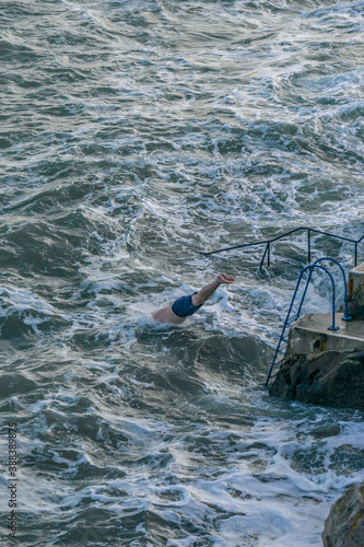 Canvas Print Man jumping into the cold Irish sea