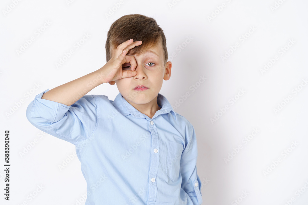 The boy expresses emotions, looks through his hands, like through binoculars. Isolated on white background. The boy expresses emotions, looks through his hands, like through binoculars. Isolated on white background.