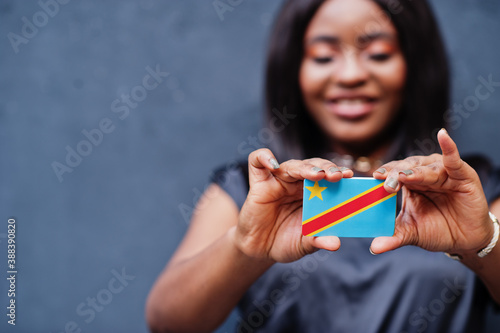 African woman hold small DR Congo flag in hands. photo