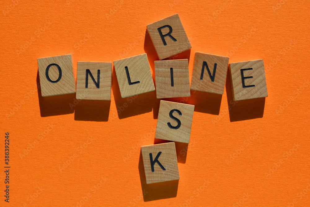 Obraz premium Online, Risk, words in wooden alphabet letters in crossword form isolated on orange background