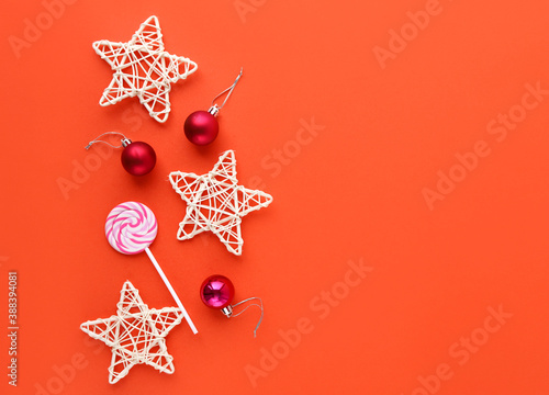 Decorative stars, Lollipop and Christmas pink Christmas balls on a red background. Christmas concept. copy space
