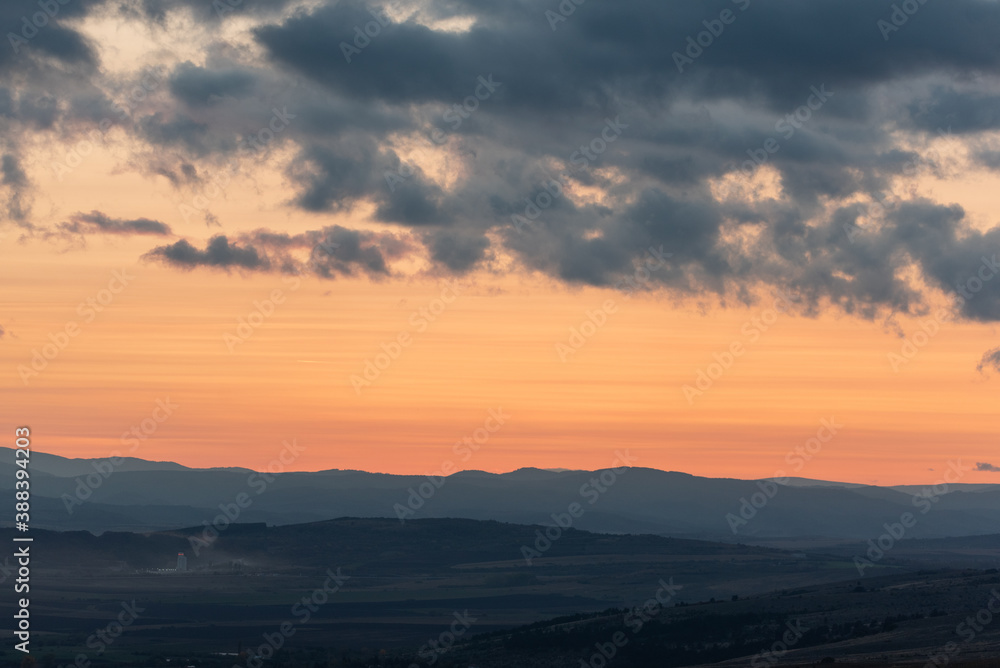 Wonderful landscape sunset clouds red orange yellow mountains fog industrial building dirty air pollution detail
