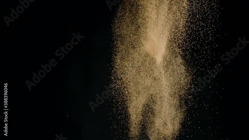 Delicious french dark chocolate truffles exploding with luster cocoa powder dust flying up, slow motion, isolated black background. Handmade chocolate candies, festive sweets, confectionery