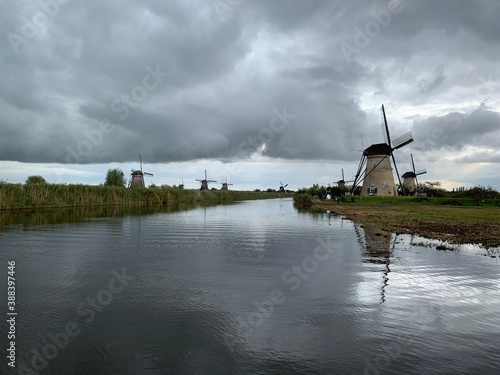 Old Dutch windmills next to the canal used for water management network. Unesco world heritage. Kinderdijk, South Holland / Netherlands 