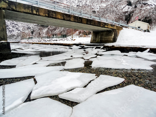 Winter landscape frozen river lake fjord, ice banks bridge, Norway. photo