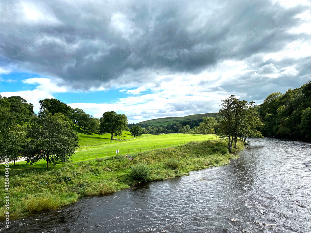 Heavy cloud, over the river Wharfe, with old trees and grassy banks in, Barden, Skipton, UK Heavy cloud, over the river Wharfe, with old trees and grassy banks in, Barden, Skipton, UK